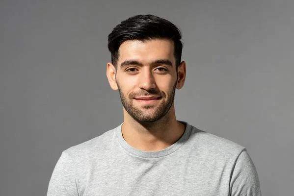 close-up-portrait-of-smiling-handsome-young-caucasian-man-face-looking-at-camera-on-isolated-light-gray-studio-background-photo.webp